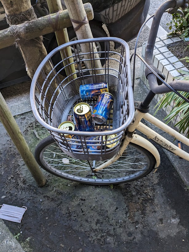 自転車かごに大量の空き缶が